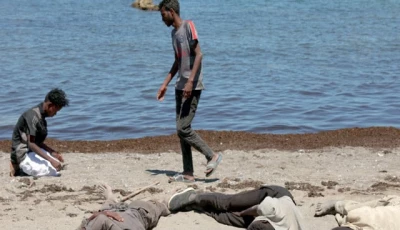 foreign land a migrant prays and others wait on the beach following mass crossings of migrants on foot and by sea from morocco into spanish territory in ceuta photo reuters