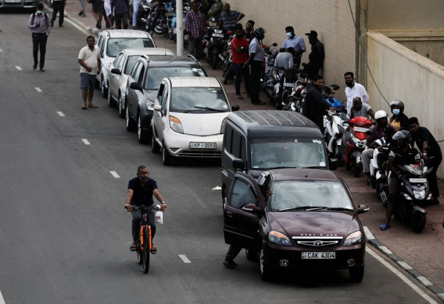a man rides a bicycle passing a petrol queue due to major fuel shortage amid the country s economic crisis in colombo sri lanka july 5 2022 photo reuters file