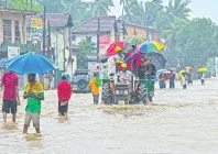 people move through a flooded road on the outskirts of colombo photo afp