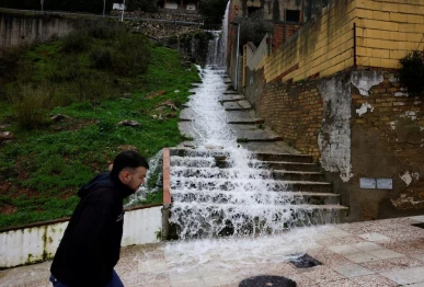 a man walks as water flows down stairs in a street due to heavy rains as storm leonardo hits parts of spain in benaojan spain on feb 6 2026 photo reuters