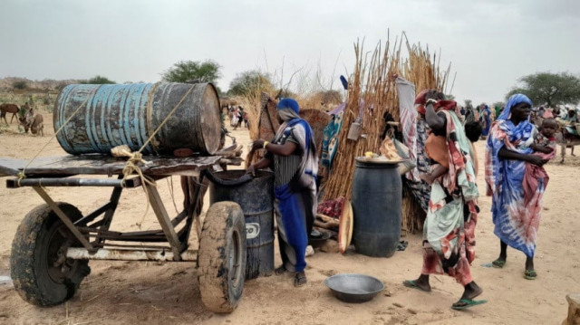 a sudanese woman who fled the violence in her country tries to get water from a barrel near the border between sudan and chad in adre chad april 26 2023 reuters mahamet ramdane