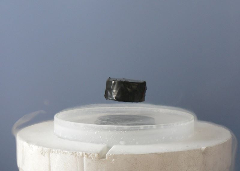 a magnet levitating above a high temperature superconductor cooled with liquid nitrogen persistent electric current flows on the surface of the superconductor photo wikimedia commons