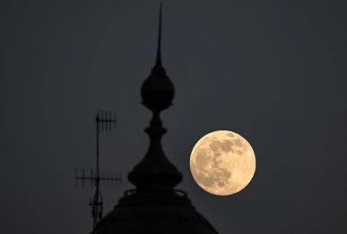 the supermoon known as the beaver moon is seen behind an office building in mexico city on november 4 2025 photo afp