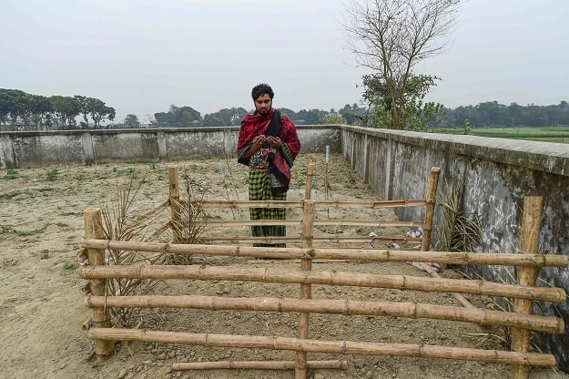 This photograph shows Mukul Seikh praying in front of the grave of his mother, former sex worker Hamida Begum. PHOTO: AFP