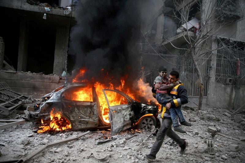 a syrian civil defence member carries a wounded child in the besieged town of hamoria eastern ghouta in damascus syria january 6 2018 photo reuters