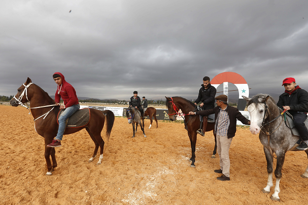 Horse trainer Jihad Ghazal holds the harness of a horse named Nejm (star in Arabic) at a track in the town of Dimas, west of the Syrian capital Damascus on December 5, 2018. PHOTO: AFP