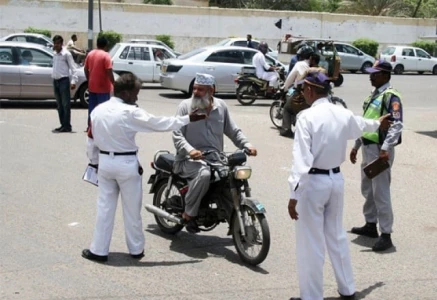 traffic police officers questioning to a bike rider in karachi photo express