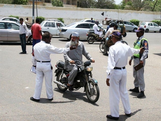 traffic police officers questioning to a bike rider in karachi photo express