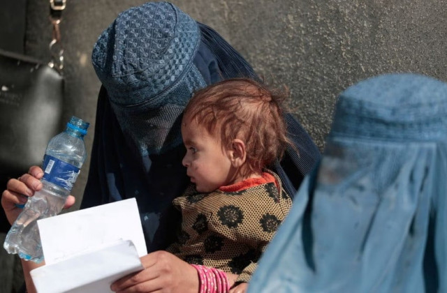 a displaced afghan woman holds her child as she waits with other women to receive aid supply outside an unchr distribution center on the outskirts of kabul afghanistan october 28 2021 reuters zohra bensemra a displaced afghan woman holds her child as she waits with other women to receive aid supply outside an unchr distribution center on the outskirts of kabul afghanistan october 28 2021 reuters zohra bensemra
