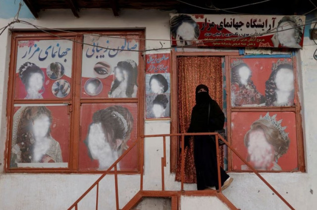 a woman wearing a niqab enters a beauty salon where the ads of women have been defaced by a shopkeeper in kabul afghanistan october 6 2021 reuters jorge silva file photo a woman wearing a niqab enters a beauty salon where the ads of women have been defaced by a shopkeeper in kabul afghanistan october 6 2021 reuters jorge silva file photo