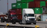 trucks drive past cargo shipping containers at the evergreen shipping terminal at the port of los angeles in los angeles california on september 13 2025 the us supreme court ruled on february 20 that donald trump exceeded his authority in imposing a swath of tariffs that upended global trade blocking a key tool the president has wielded to impose his economic agenda photo afp