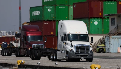 trucks drive past cargo shipping containers at the evergreen shipping terminal at the port of los angeles in los angeles california on september 13 2025 the us supreme court ruled on february 20 that donald trump exceeded his authority in imposing a swath of tariffs that upended global trade blocking a key tool the president has wielded to impose his economic agenda photo afp