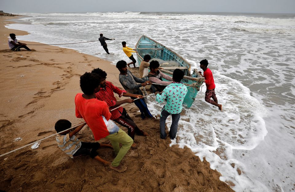 people move a fishing boat to a safer place along the shore ahead of cyclone tauktae in veraval in the western state of gujarat india may 17 2021 photo reuters