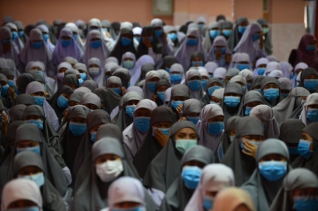 Thai Muslim students wear face masks donated by a school official as a preventive measure against the COVID-19 coronavirus during a ceremony in Thailand. PHOTO: AFP