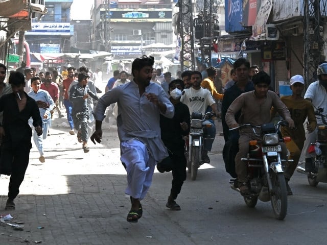 TLP party activists run as they escape police personnel during an anti-Israel protest in Muridke on October 13. Photo: AFP