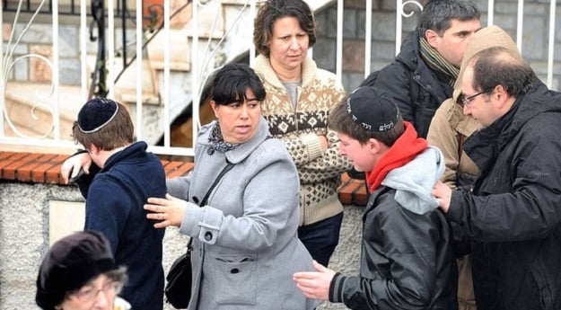 Adults comfort students as they walk away from the Ozar Hatorah Jewish school in Toulouse, France. PHOTO: AFP