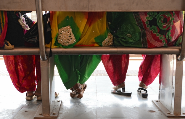 Indian passengers sit on a bench as they wait for a train at Gandhinagar railway station in Jaipur. PHOTO: AFP