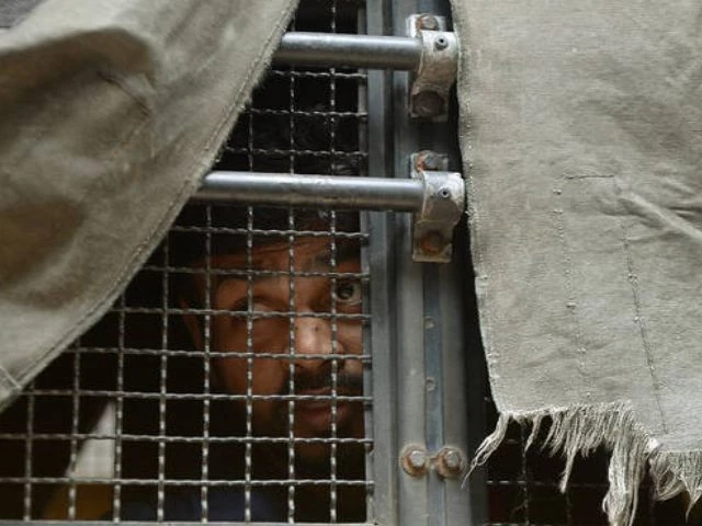 an indian prisoner convicted of involvement in the 2006 mumbai train blasts looks out from a police van on his way to a special court in mumbai on september 16 2015 afp file