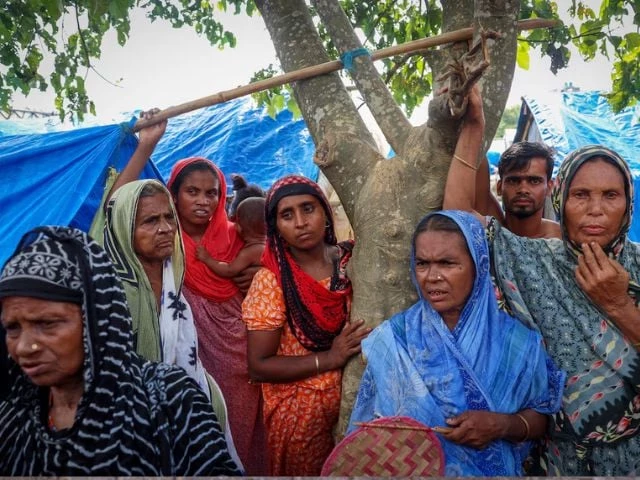 women stand under a tree inside a makeshift shelter camp in goalpara district in the northeastern state of assam india july 18 2025 reuters sahiba chawdhary