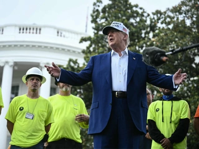 us president donald trump speaks to the press as workers install a large flag pole on the south lawn of the white house in washington dc on june 18 2025 photo afp