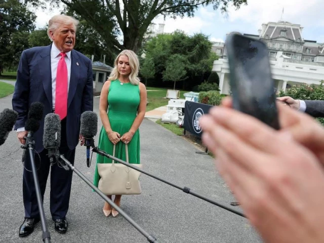 us president donald trump speaks with reporters while white house press secretary karoline leavitt stands next to him as he departs for travel to pennsylvania from the south lawn at the white house in washington dc us july 15 2025 reuters