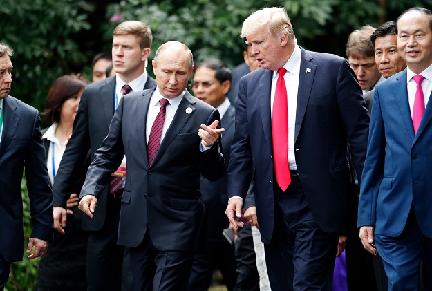 US President Donald Trump (R) and Russia's President Vladimir Putin chat as they walk together to take part in the 