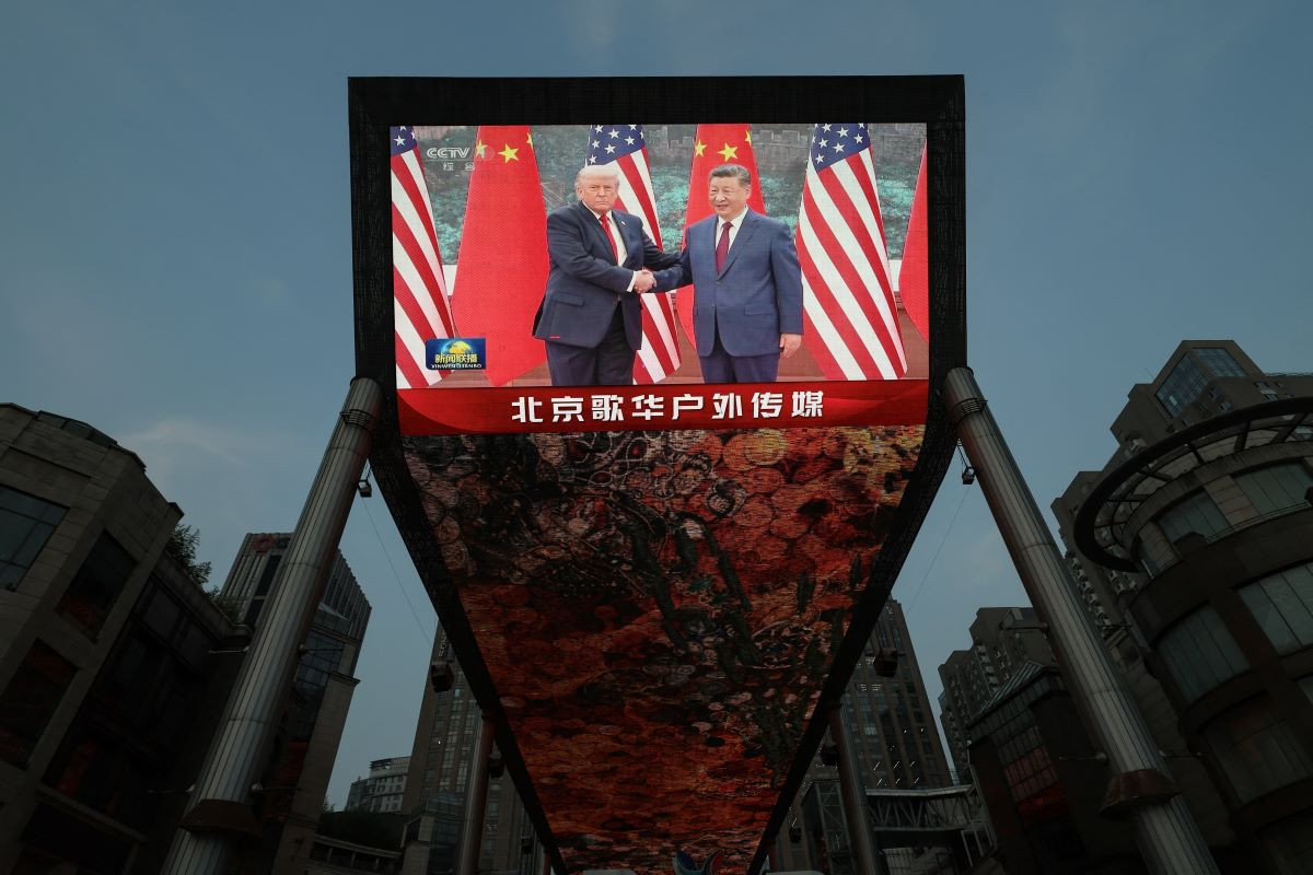 giant screen at a shopping area shows news footage of Chinese President Xi Jinping meeting US President Donald Trump at the Great Hall of the People, in Beijing, China May 14, 2026. REUTERS