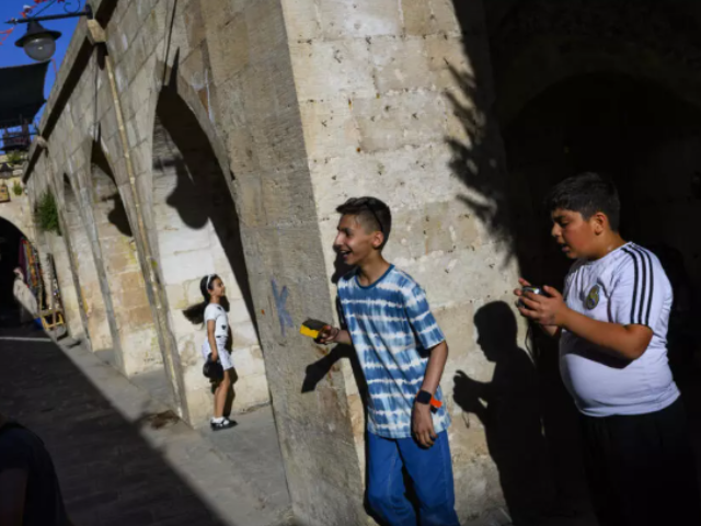 Children take photos with their film cameras during a workshop organized as part of the