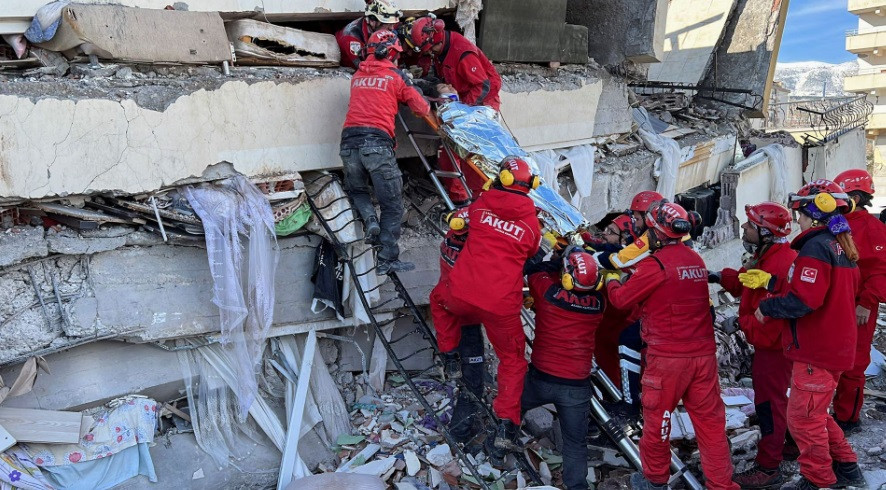 Rescuers carry a woman after she was evacuated from under a collapsed building following an earthquake in Kahramanmaras, Turkey, February 7, 2023. REUTERS/Suhaib Salem