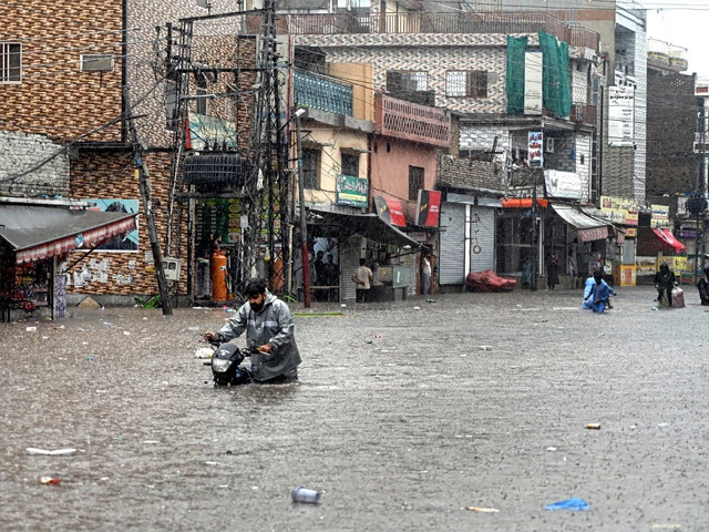 a motorcyclist wades through floodwater on dhok khabba road after heavy rain submerged streets in the twin cities on july 17 photo app