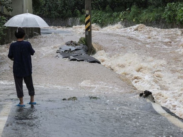 a woman looks at a road submerged during typhoon khanun in gunwi south korea august 10 2023 photo reuters