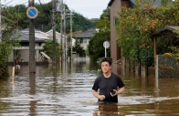 a man wades through a flooded road after typhoon dujuan brought torrential rain to sakura chiba prefecture japan september 22 2026 photo reuters