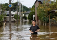 a man wades through a flooded road after typhoon dujuan brought torrential rain to sakura chiba prefecture japan september 22 2026 photo reuters