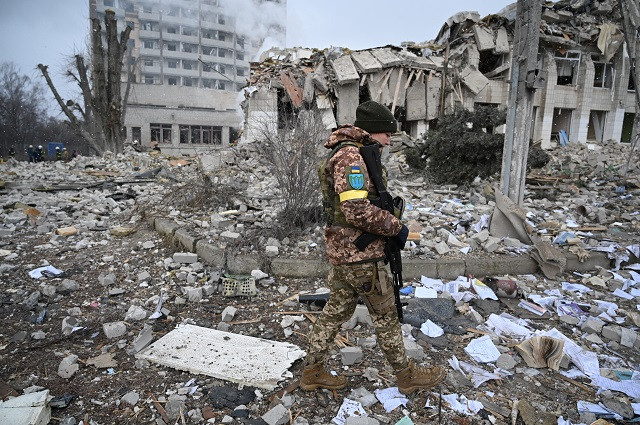 a ukrainian service member walks near a building destroyed by shelling photo reuters