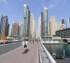 people walk across a bridge in the emirate of dubai photo file
