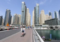 people walk across a bridge in the emirate of dubai photo file