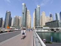 people walk across a bridge in the emirate of dubai photo file