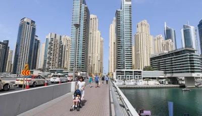 people walk across a bridge in the emirate of dubai photo file