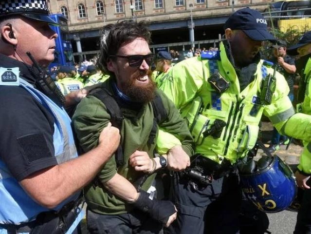 an opposition protester is arrested during protests against a britain first march for remigration demonstration in manchester on aug 2 2025 photo afp an opposition protester is arrested during protests against a britain first march for remigration demonstration in manchester on aug 2 2025 photo afp