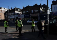 an orthodox jewish man walks past security patrolling the street near where a man was arrested on wednesday following a stabbing incident in which two jewish men were wounded in the golders green area in london britain april 30 2026 photo reuters