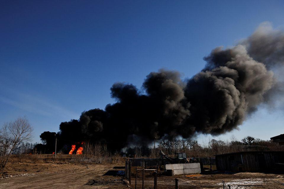 a column of smoke rises from burning fuel tanks that locals said were hit by five rockets at the vasylkiv air base following russia s invasion of ukraine outside kyiv ukraine march 12 2022 photo reuters