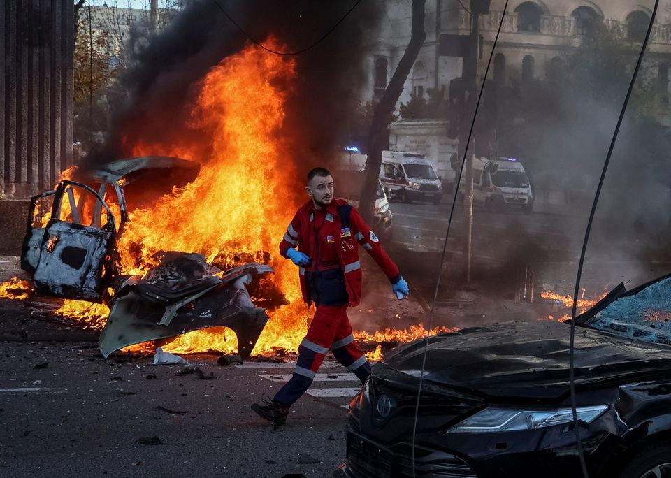 a medical worker walks near a burned car after russian military strike as russia s invasion of ukraine continues in central kyiv ukraine october 10 2022 photo reuters