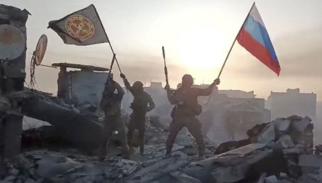 wagner mercenary group fighters wave flags of russia and wagner group on top of a building in an unidentified location in the course of the russia ukraine conflict in this still image obtained from a video released on may 20 2023 along with a statement by russian mercenary chief yevgeny prigozhin about taking full control of the ukrainian city of bakhmut press service of concord handout via reuters wagner mercenary group fighters wave flags of russia and wagner group on top of a building in an unidentified location in the course of the russia ukraine conflict in this still image obtained from a video released on may 20 2023 along with a statement by russian mercenary chief yevgeny prigozhin about taking full control of the ukrainian city of bakhmut press service of concord handout via reuters