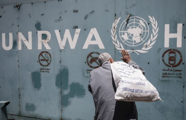 a file picture shows a palestinian man standing in front of the emblem of the un agency for palestinian refugees outside its offices in gaza city a file picture shows a palestinian man standing in front of the emblem of the un agency for palestinian refugees outside its offices in gaza city