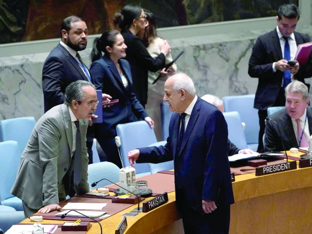 palestinian ambassador to un riyad mansour speaks with pakistan s envoy asim iftikhar ahmad during a un security council meeting at the un photo afp