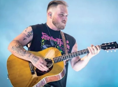 zach bryan sports free palestine shirt during performance