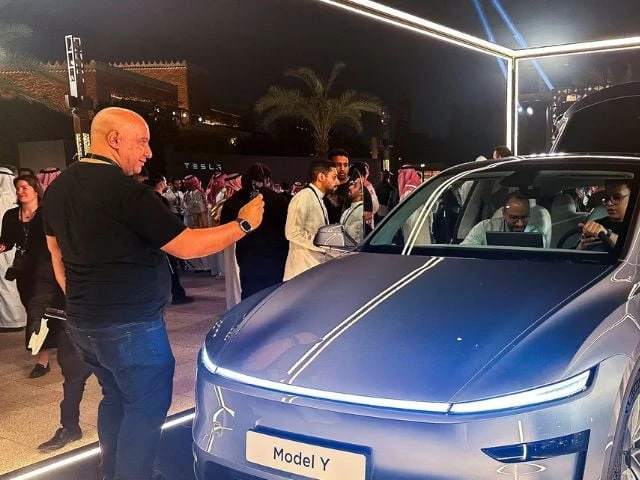 a guest takes photos of tesla model y displayed during the inauguration ceremony of the first tesla showroom in riyadh saudi arabia april 10 2025 photo reuters