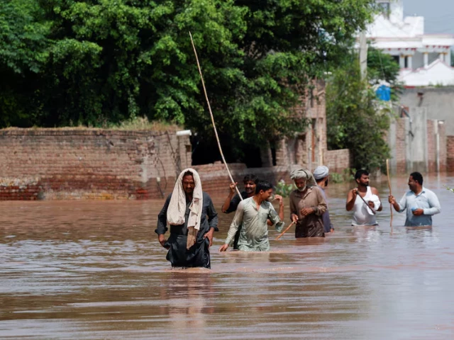 residents wade through a flooded road following monsoon rains and rising water levels in qadirabad village near the chenab river in punjab province pakistan august 28 2025 photo reuters