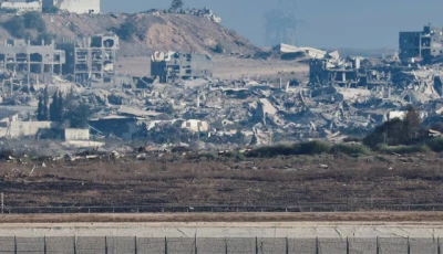 tanks stand on the israeli side of the border as destruction in gaza is seen in the background photo reuters