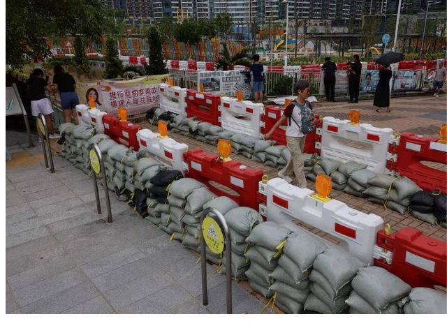 residents walk past sandbags placed to prevent flooding from super typhoon ragasa in hong kong china september 23 2025 reuters